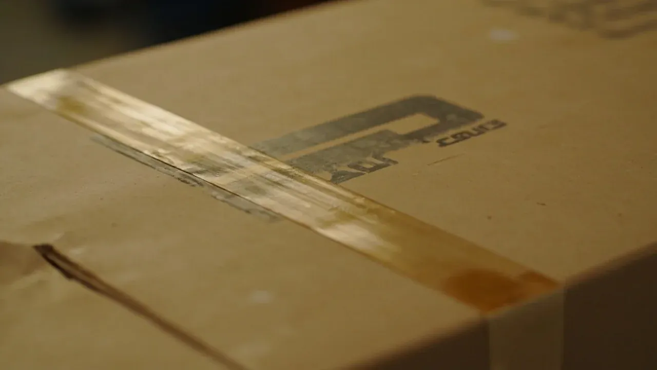 Close-up of the lid joint beside a taped carton seam