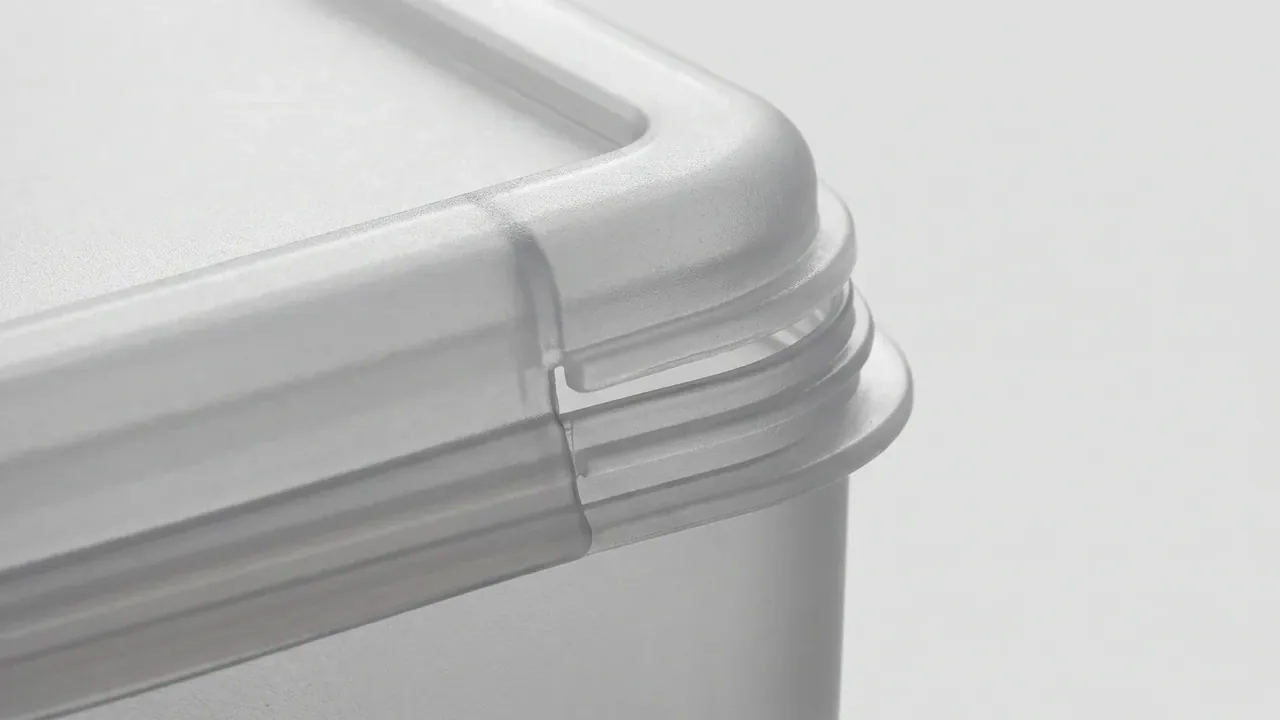 Cartridge Storage Box: close view of a pale grey case corner, the lid rim sitting over the wall mouth in one joint line, ribs and fine texture across the surfaces