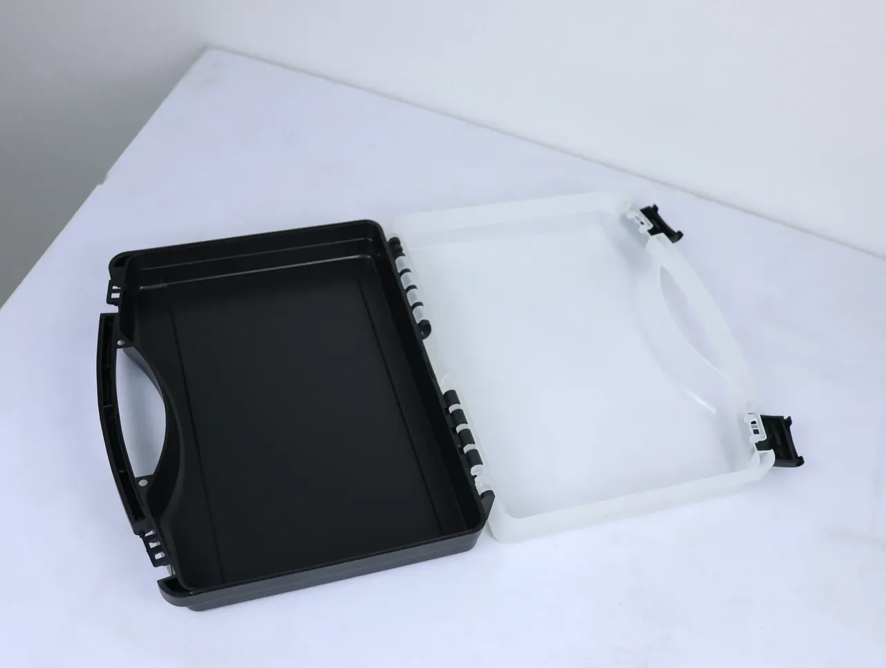 Case Assembly Workstation: black base and milky lid side by side, white hinge pins in a row, black latch at each lid corner