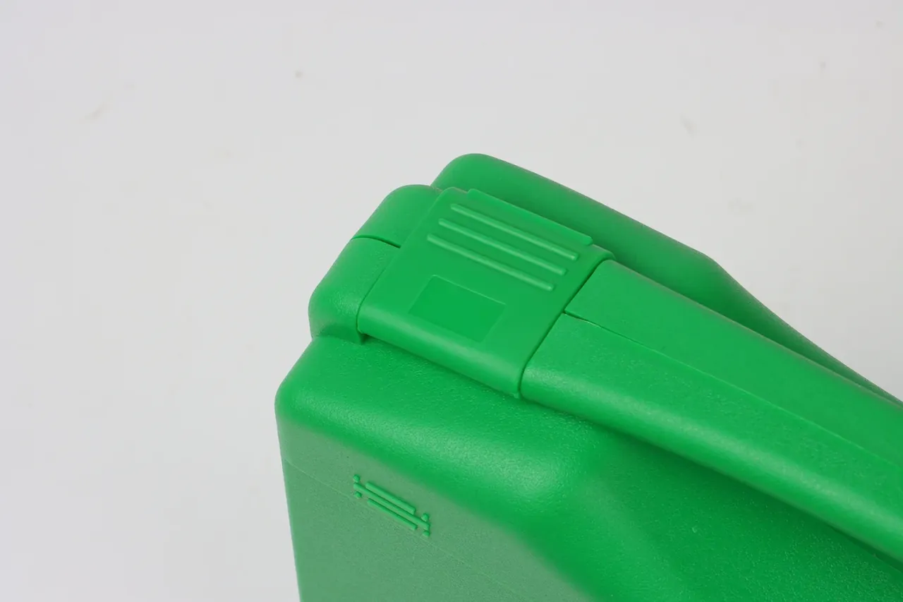 Case Export Packaging: green case latch at the corner, three parallel ribs on the lid edge and a square pad