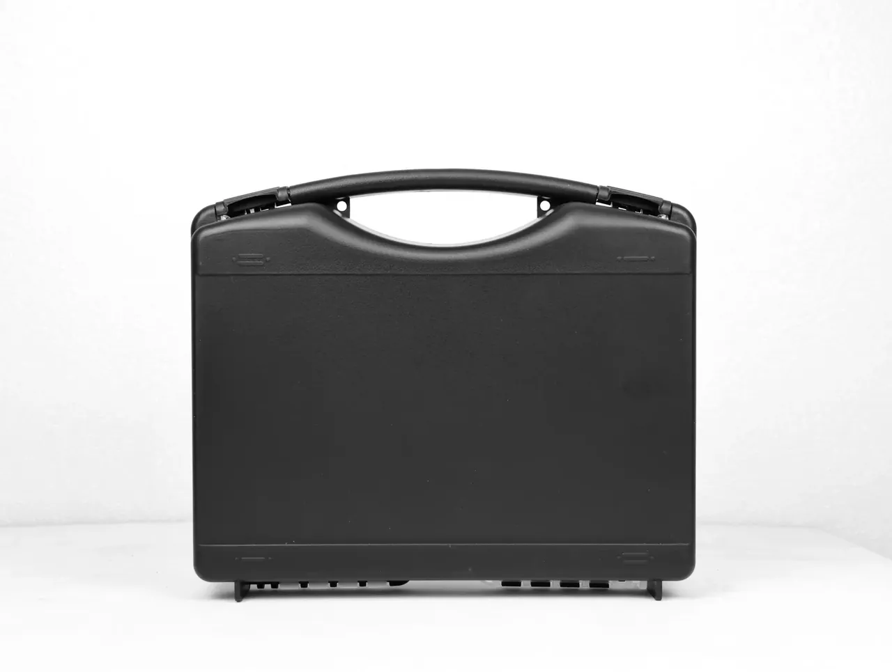 Case Injection Molding Machine output: matte black case face-on, screw bosses inside the handle, three square feet below
