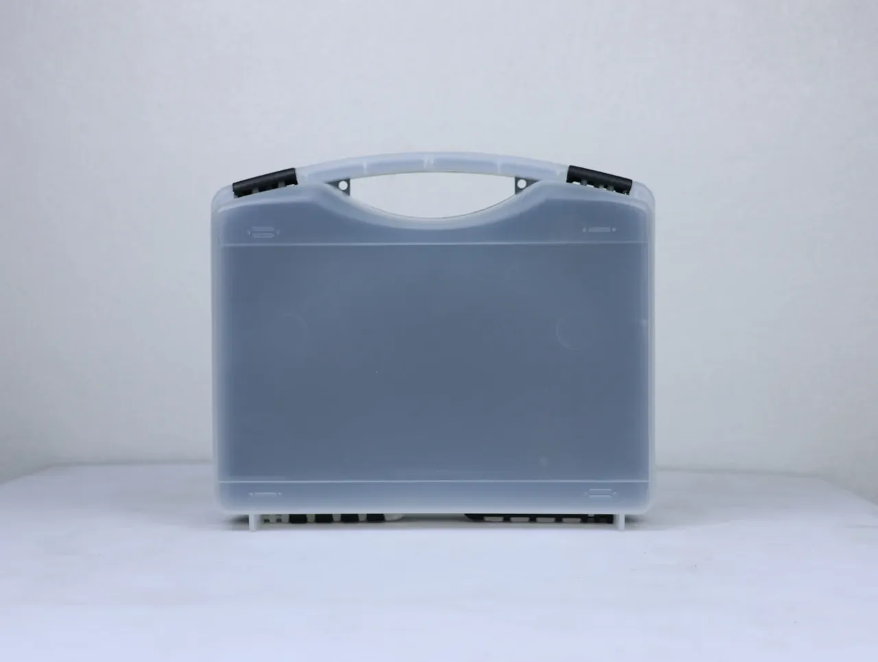 Case Injection Molding Machine output: matte translucent case face-on, two round holes inside the handle, three black feet