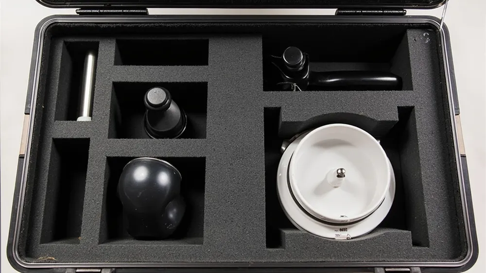 Foam cutouts holding a portafilter, tamper and scale in a coffee case