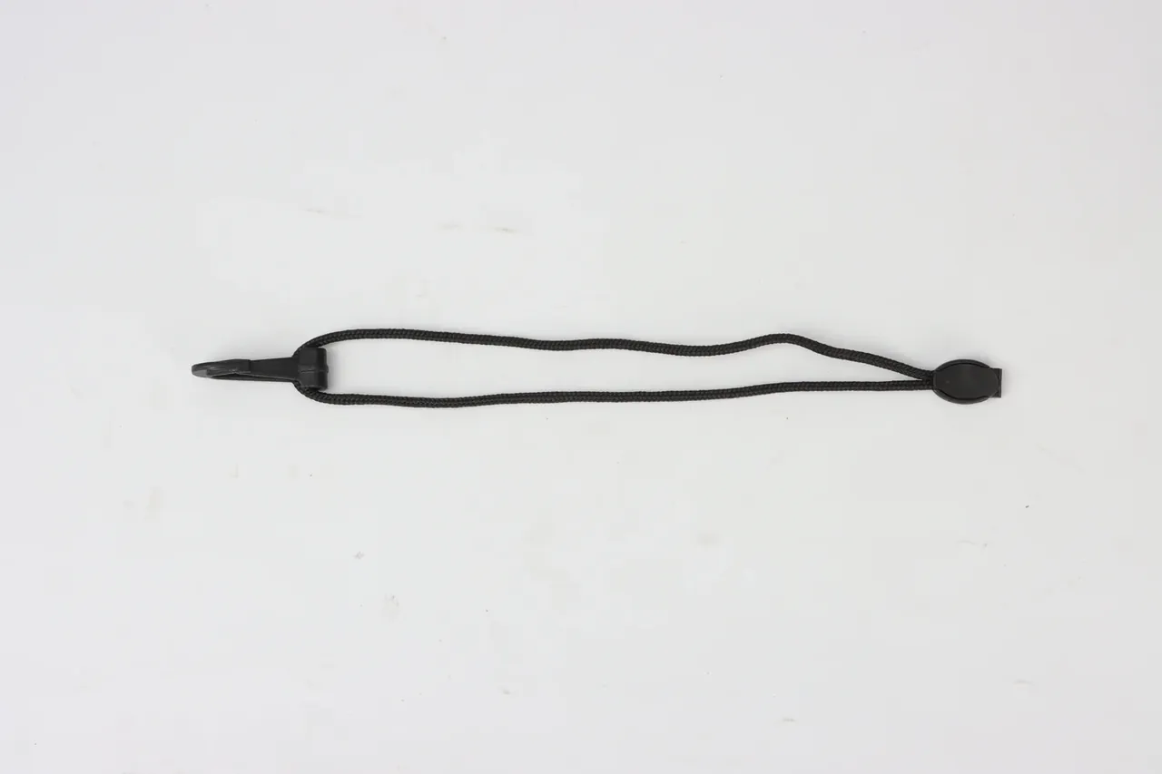 A black braided cord laid flat, a moulded plastic fitting at each end, slim left and disc-shaped right