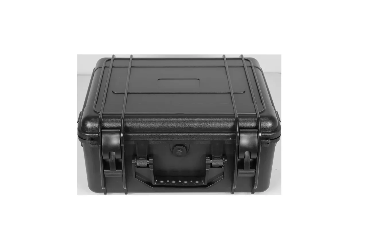 The lid from above: two ribs crossing it into the latches, a round knob at centre, the handle folded at the lower edge