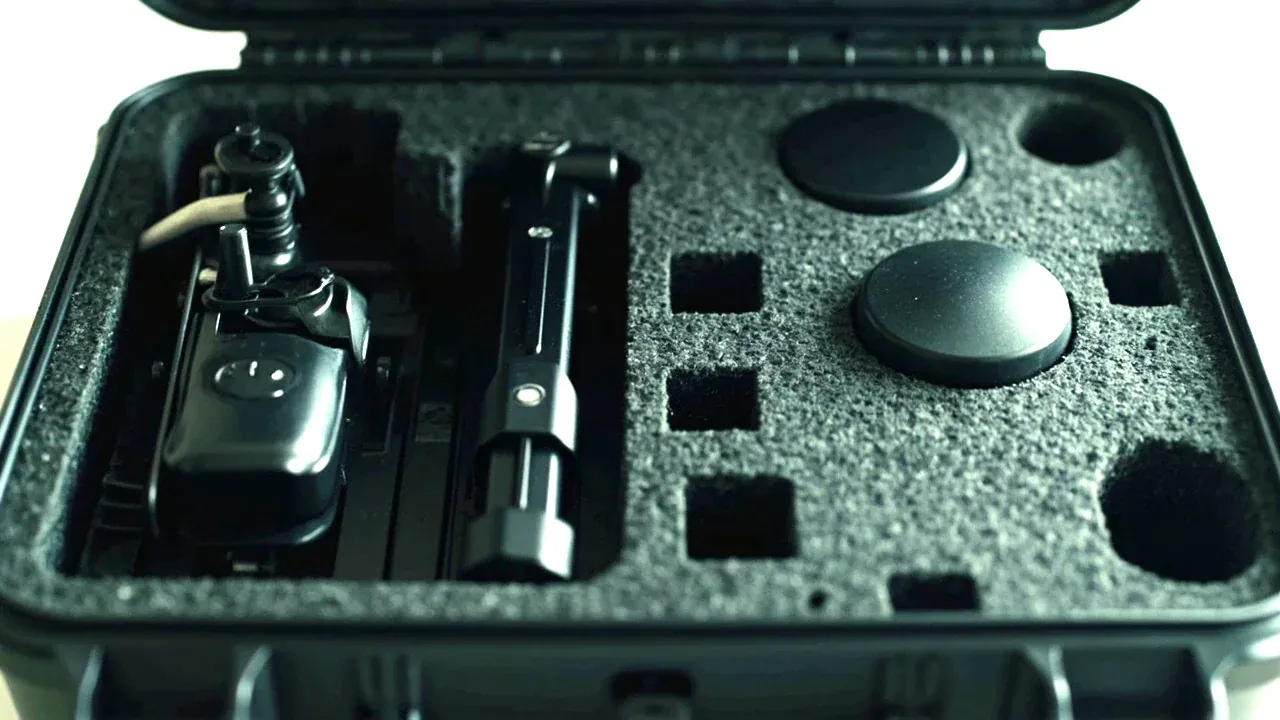 A gimbal and camera module in a foam cut-out inside a drone case, protective caps on