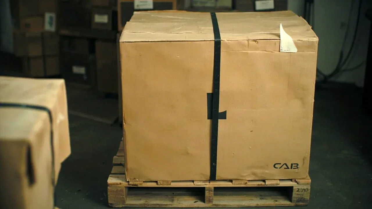 The long case strapped on a pallet with the cabinet fixed to the wall behind