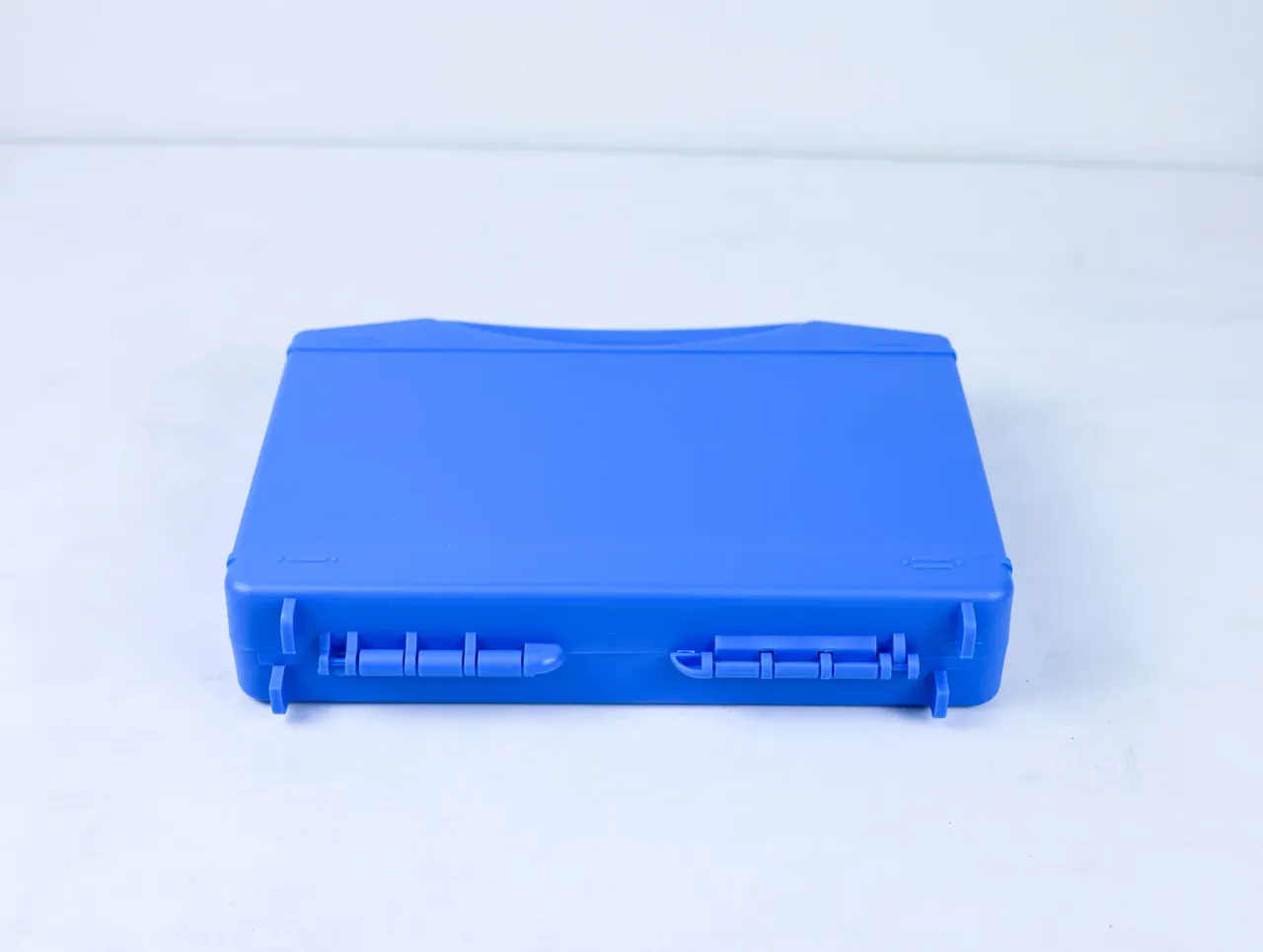 Large Protective Case: the same blue case flat on white, two long toothed latches across the lower edge and a shallow lid curve
