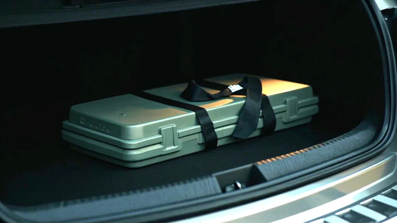A medical case secured by a strap in the boot of a vehicle, lid closed
