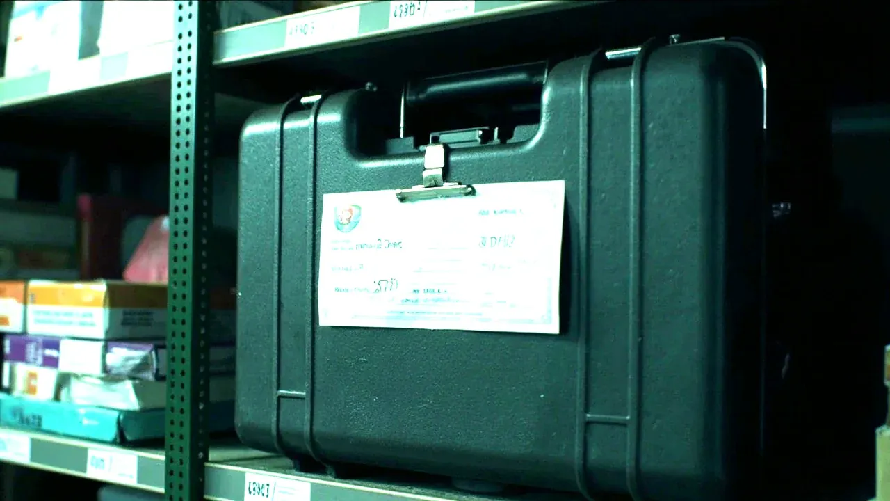 A medical case with a check card clipped to the lid after restocking, on a shelf