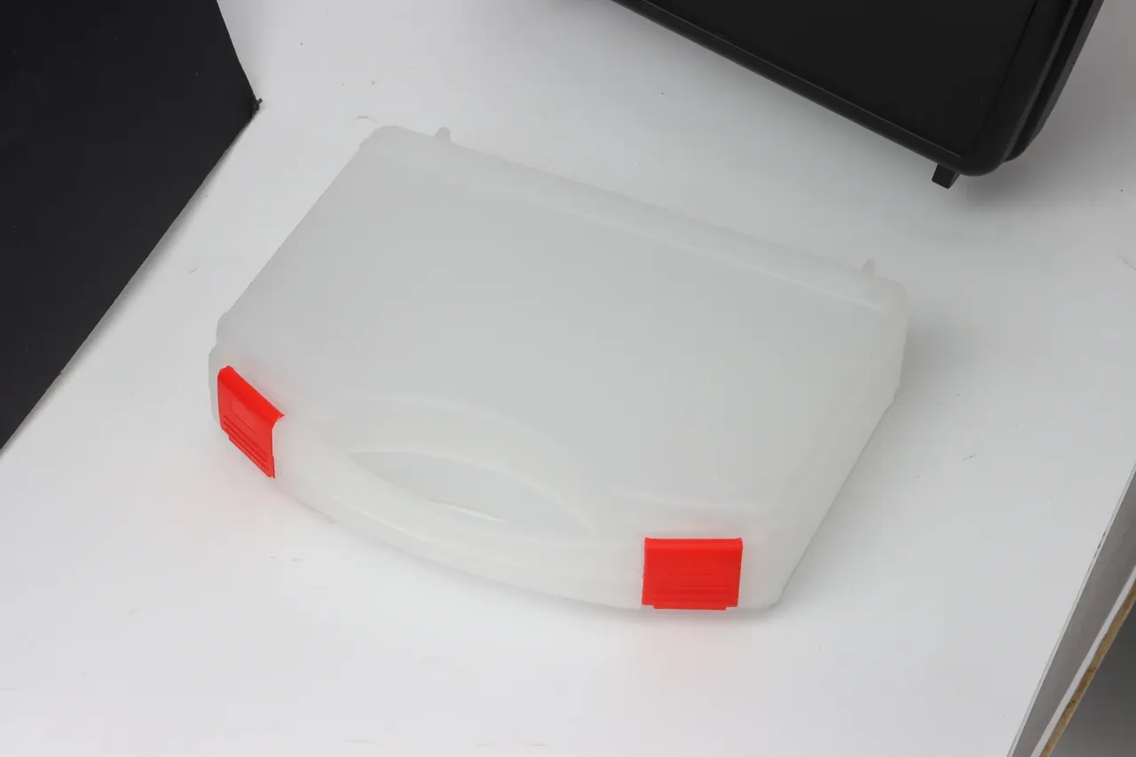 Military Supply Case: milky-white translucent case angled on white, a red latch at each front corner, oval recess in the lid