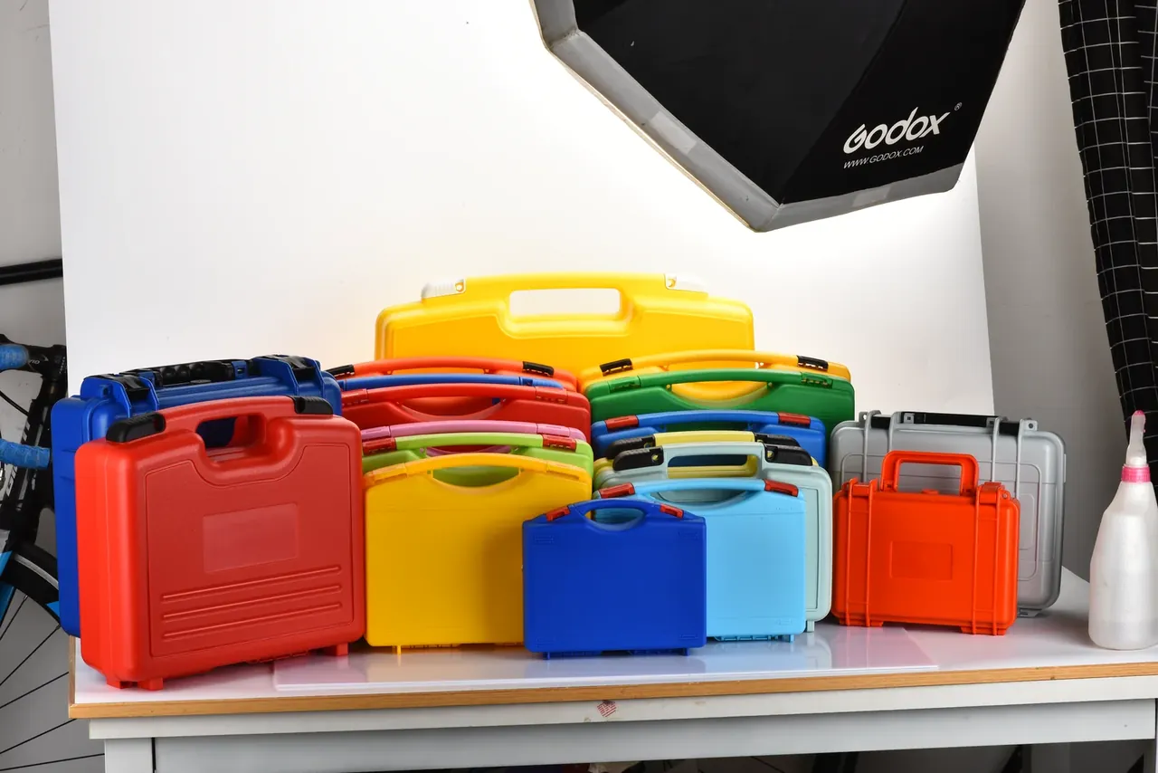 Several missile boxes of one family side by side on a bench, red, yellow, blue, green, light blue, grey and orange, latches aligned
