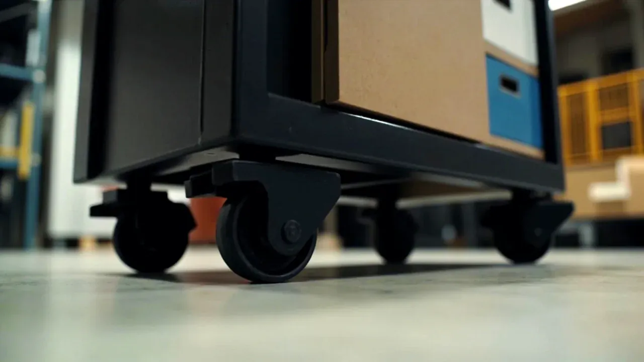Close-up of the anti-tip bracket and floor fixing point at the base of a mobile tool cabinet