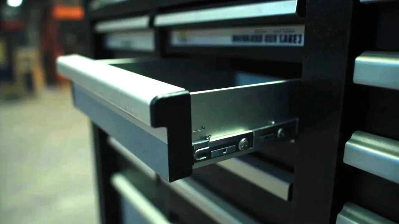 Close-up of a drawer slide and a labelled drawer front on a mobile tool cabinet
