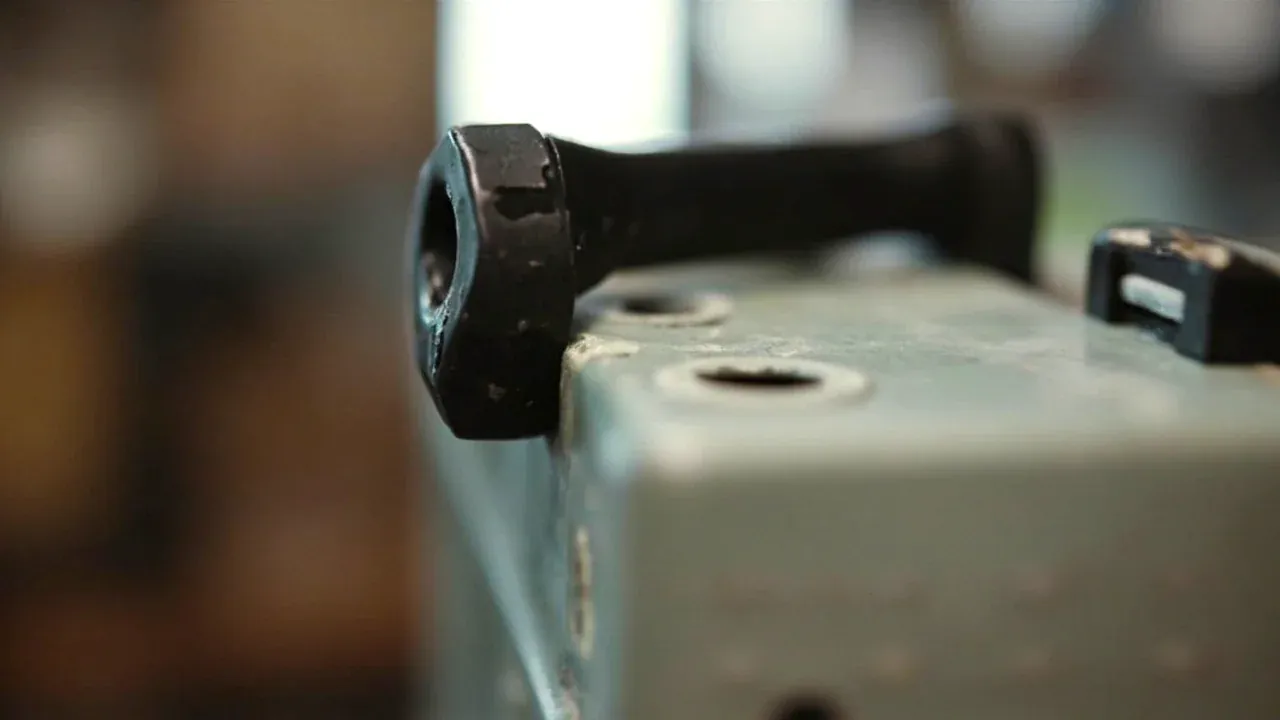 Close-up of a torn handle fixing seat on a tool box, two bolts in a stretched plastic boss