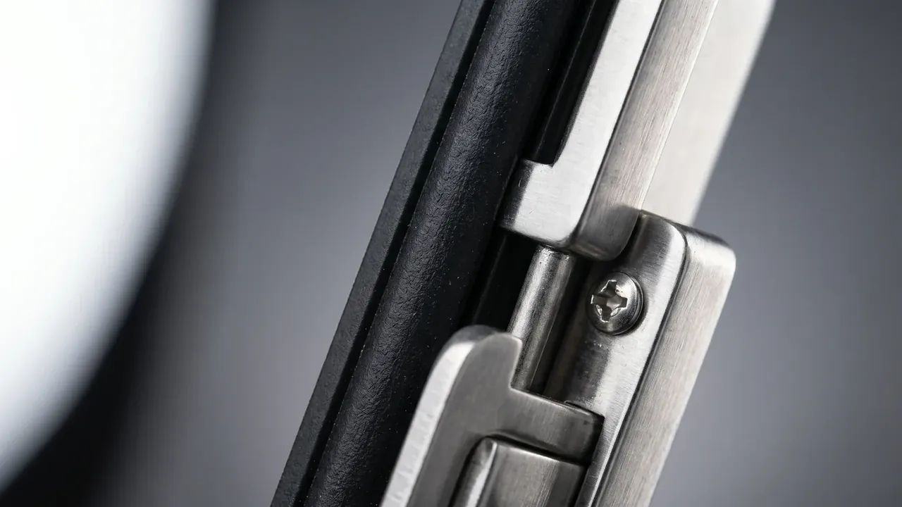 Reusable Shipping and Storage Container: brushed steel latch screwed to a black case edge, a black rubber seal running beneath it