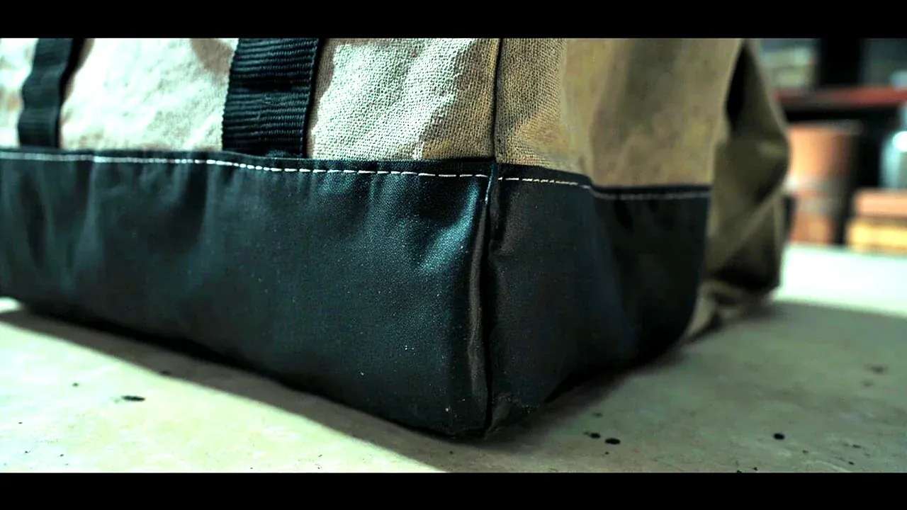 Close-up of a tool bag base corner with a dark wear-resistant base and reinforced stitching