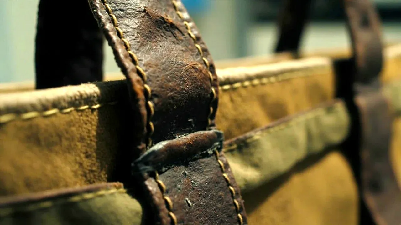 Close-up of a worn canvas tool bag handle showing stitching wear