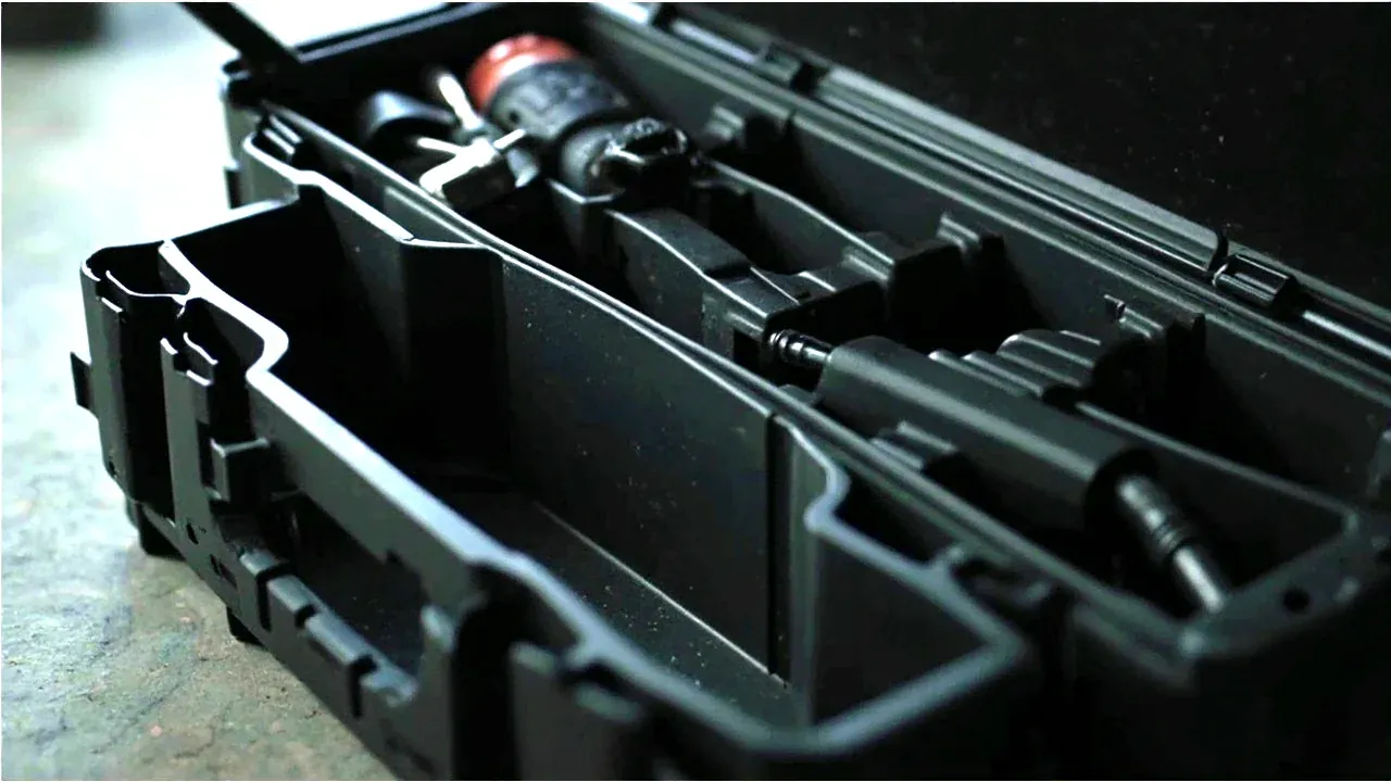 A tool carrier with adjustable internal dividers, one compartment holding tools, another empty