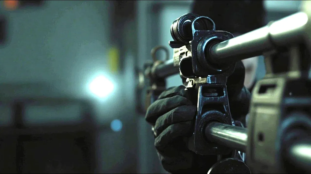 A gloved hand carrying a loaded tool carrier between two workstations in a workshop