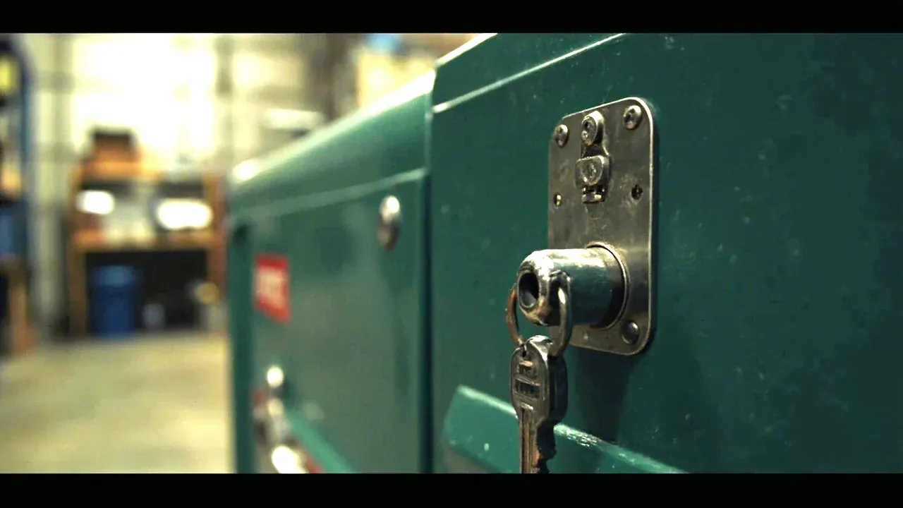 Close-up of the central lock of a tool chest with three locking points, key inserted